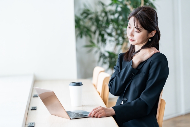 デスクワーク中に首の後ろに手をあてる女性。肩こりの原因を研究データから検証する記事のアイキャッチ